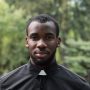 young-male-priest-holding-bible-cemetery